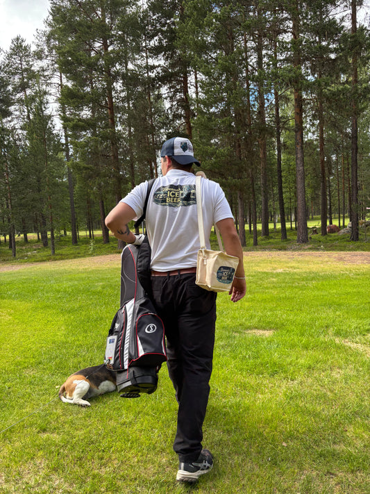 Person bär Bomans BIB kylväska med kylgel på en golfbana. Praktisk kylväska som håller öl och andra drycker kalla under golf, utflykter och friluftsliv.